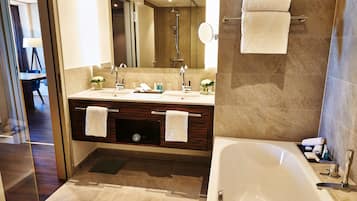 A modern bathroom with a large bathtub, a double sink vanity, and a shower area.