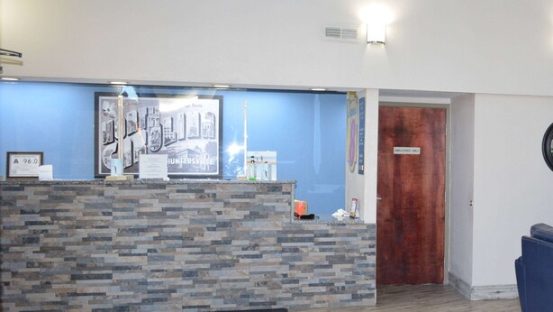 A reception area with a stone counter, a framed cityscape poster, and a door labeled "Employees Only".