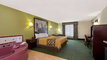 A hotel room with a bed, a large window with curtains, a desk, a chair, a desk lamp, a nightstand, a vanity with a mirror, and a bathtub.