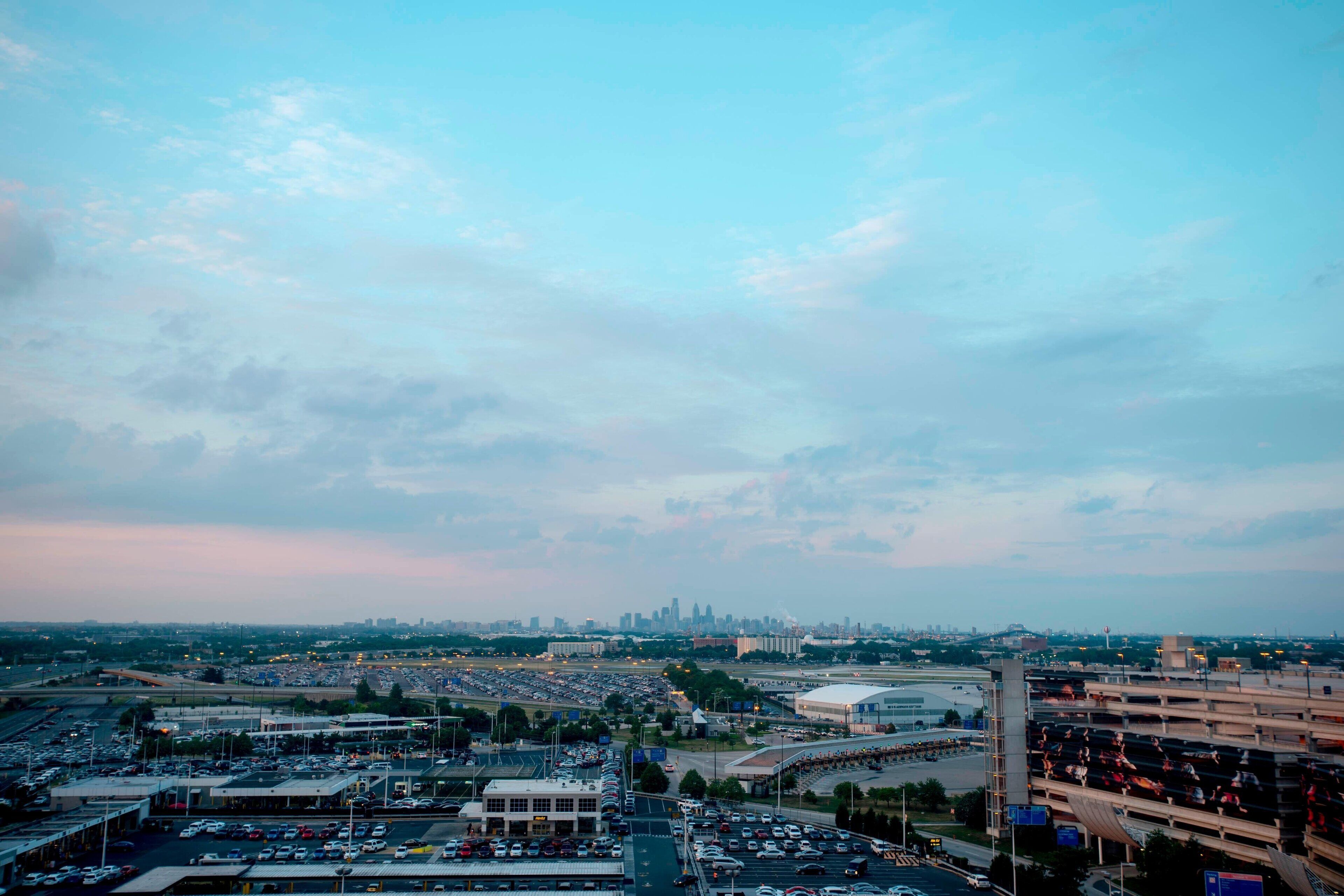 A parking lot with multiple levels of parking garages and a large stadium in the background.