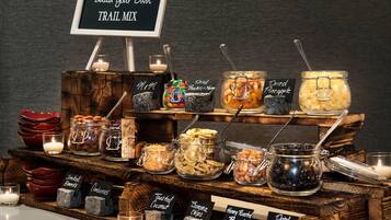 A trail mix station with various nuts, dried fruits, and snacks.