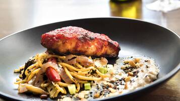 Un plato de comida con carne, fideos y verduras.