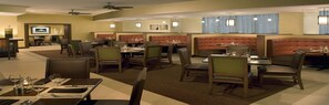 A restaurant with booths and tables, ceiling fans, and wall-mounted lights. - Four Points by Sheraton Suites Tampa Airport Westshore (Tampa)