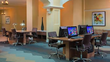 A conference room with multiple desks, chairs, and computer monitors.