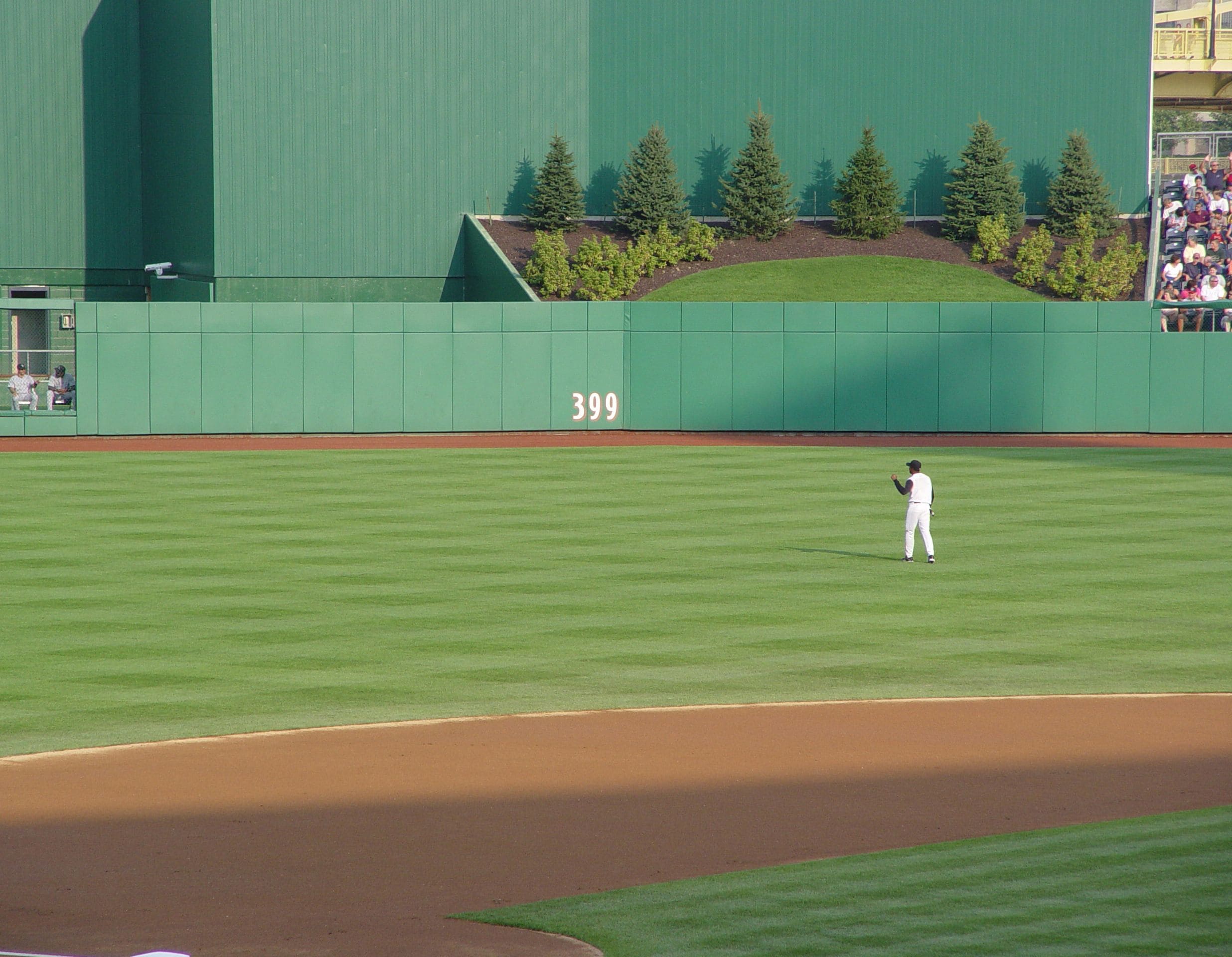 A baseball field with a player standing on the pitcher's mound.