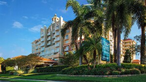 A multi-story hotel with balconies, surrounded by palm trees and well-maintained landscaping. - Four Points by Sheraton Suites Tampa Airport Westshore (Tampa)