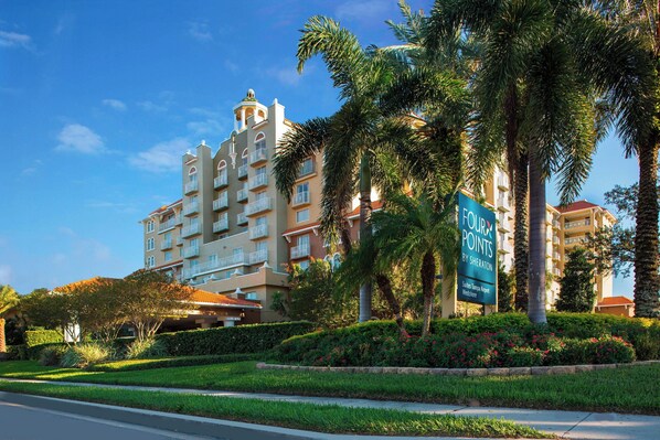 A multi-story hotel with balconies, surrounded by palm trees and well-maintained landscaping. - Four Points by Sheraton Suites Tampa Airport Westshore (Tampa)