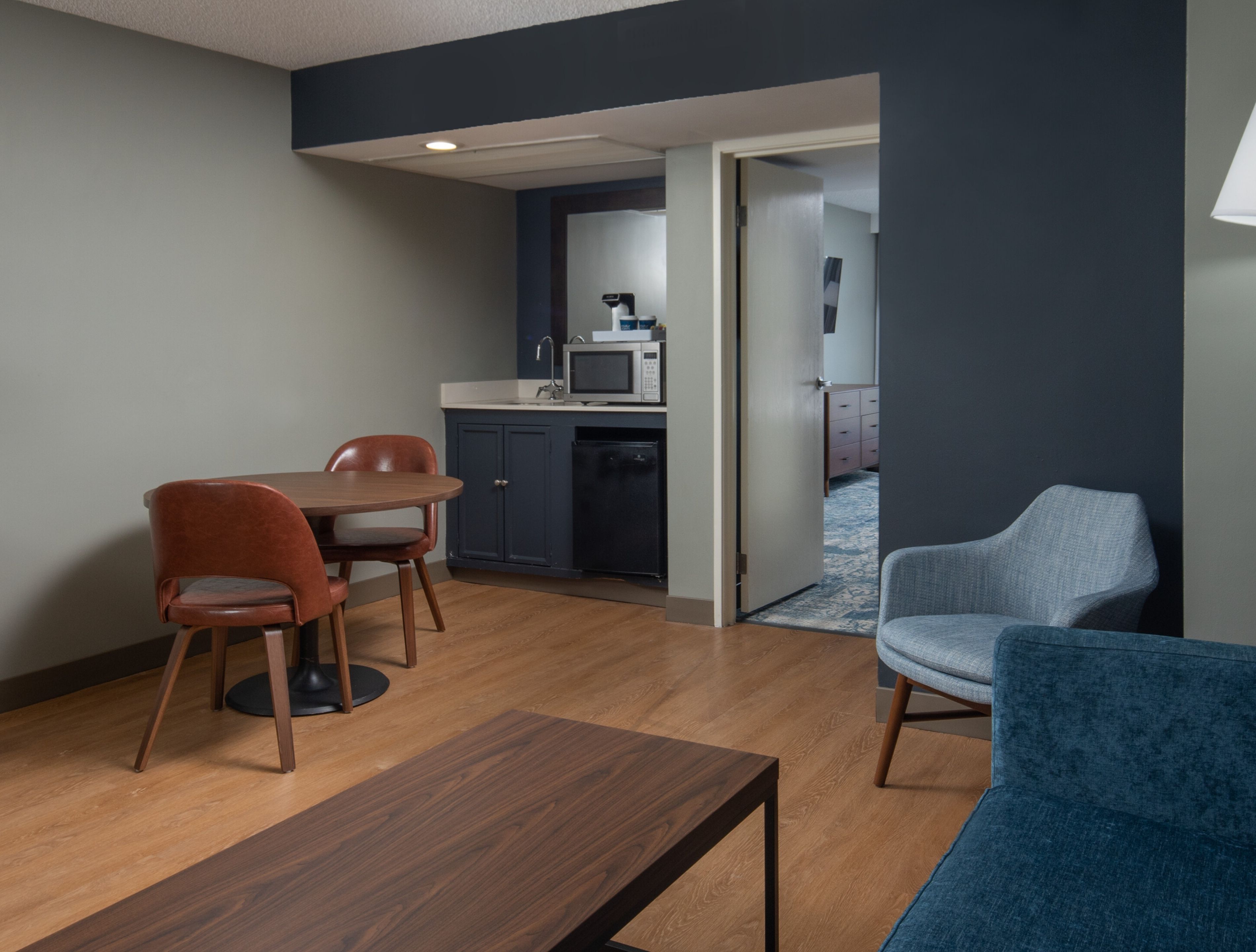 Een ruimtelijk ingerichte leefruimte met een eethoek, kitchenette en zithoek.