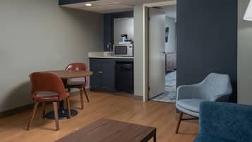 Un espacio habitable compacto con comedor, kitchenette y zona de estar.
