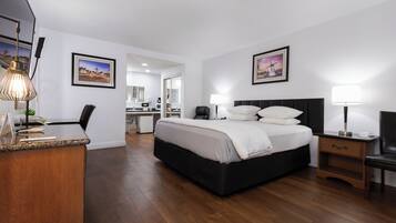 Una habitación de hotel con cama, mesitas de noche, escritorio y una silla.