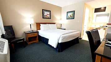 Quarto de hotel com uma cama, duas mesas de cabeceira, uma escrivaninha e uma cadeira.