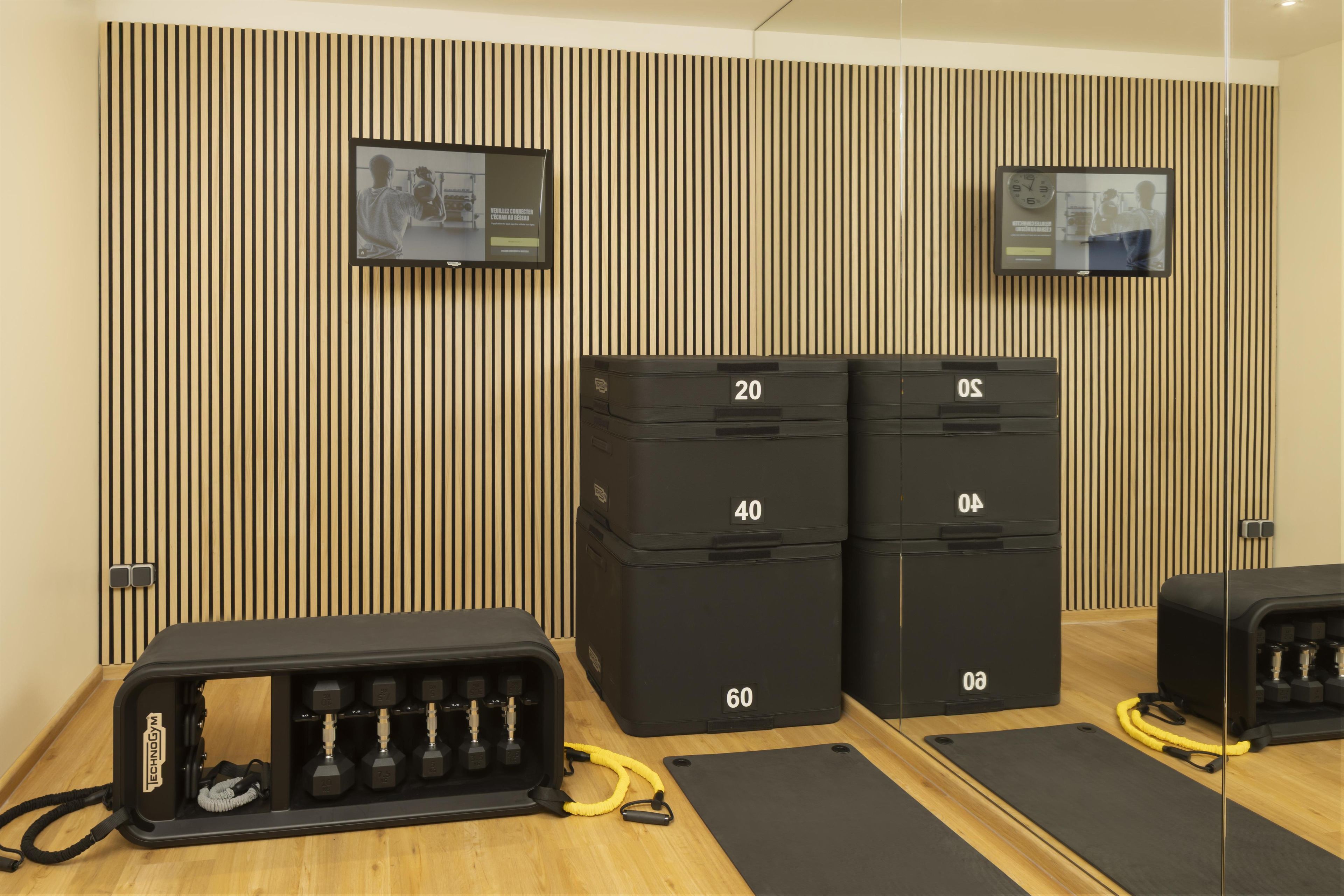 A gym with exercise equipment, including dumbbells and resistance bands, and storage units labeled with numbers.
