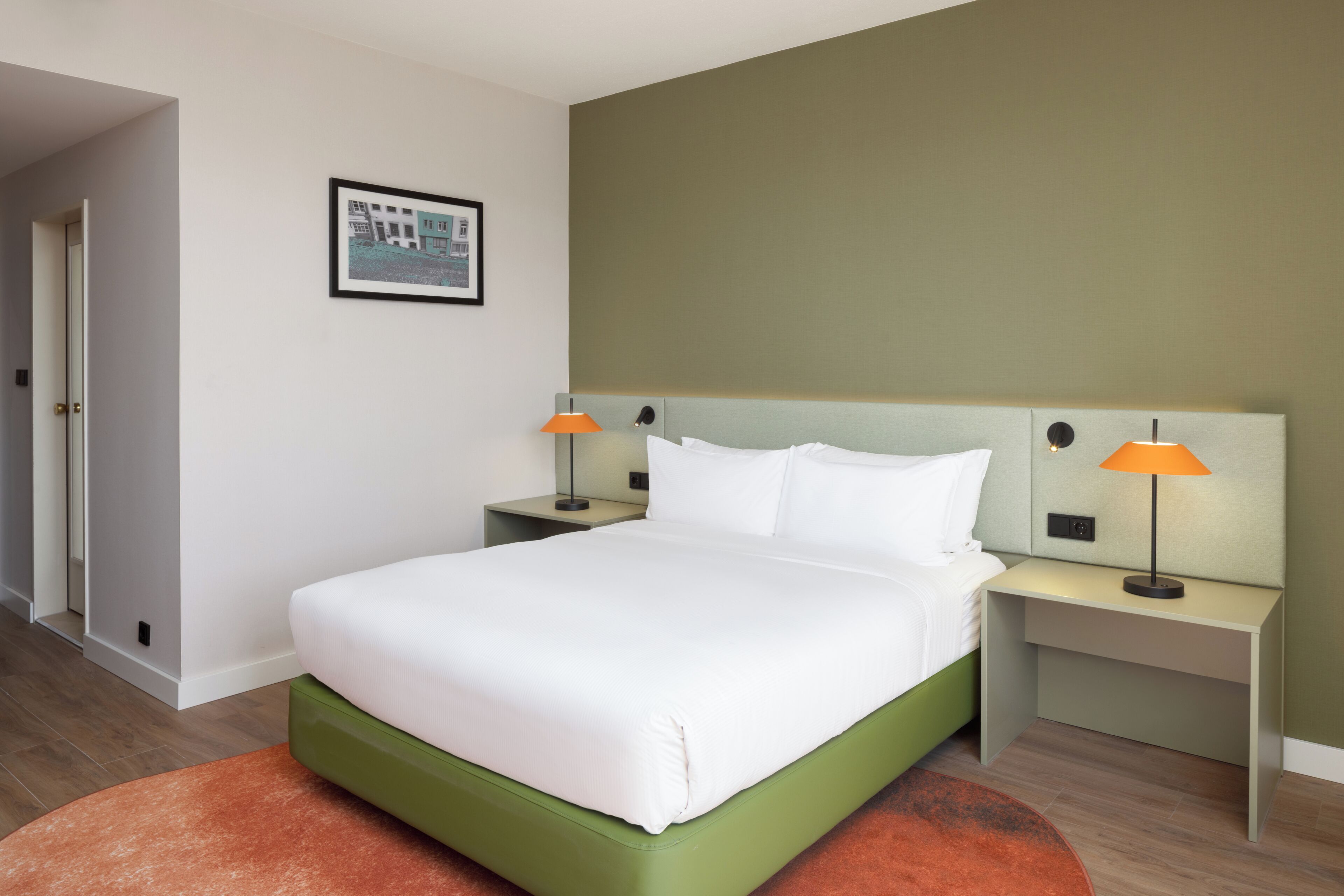 A neatly arranged hotel room with a bed, two bedside tables, and a nightstand.