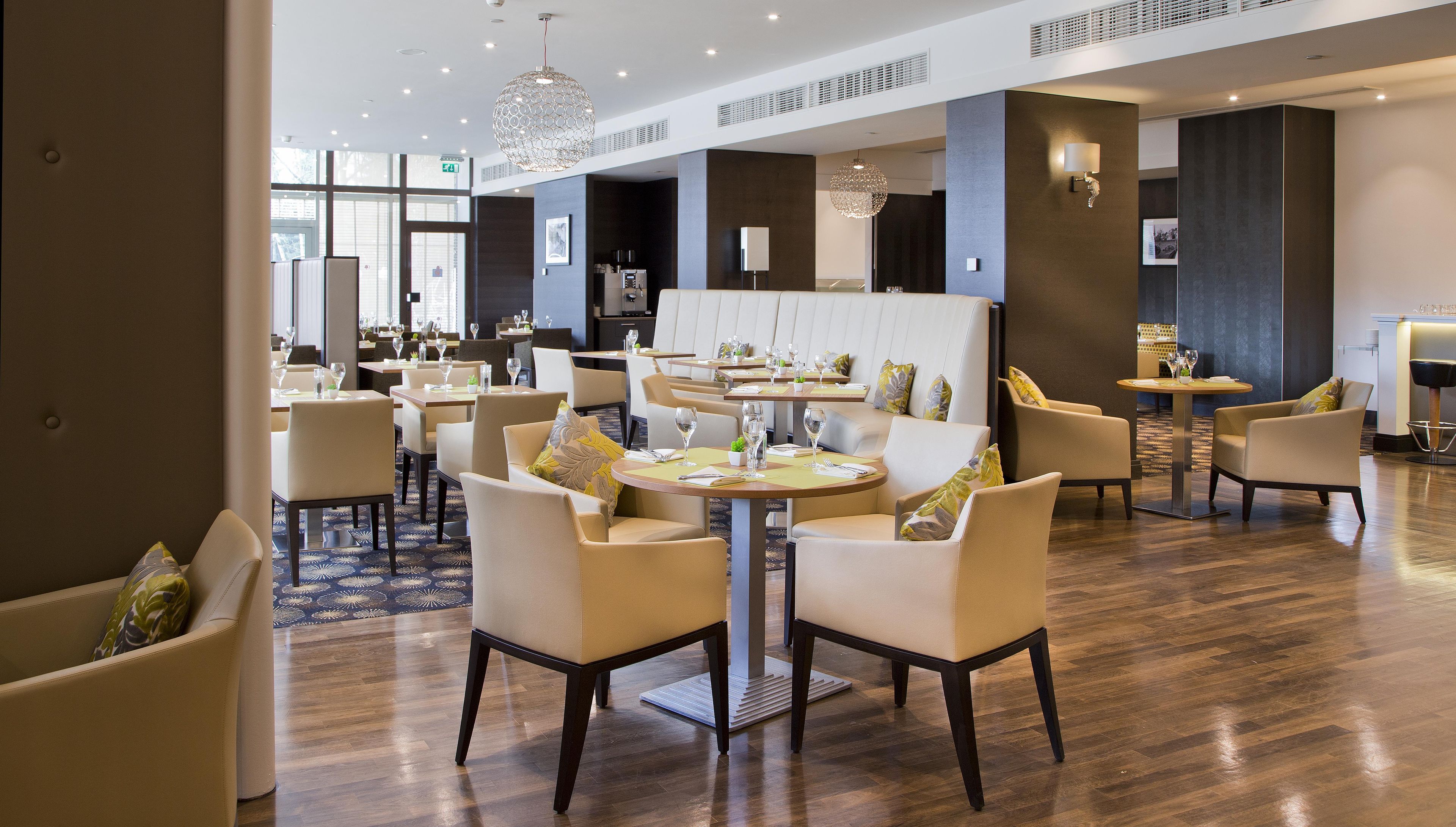 Un hall d’hôtel doté de plusieurs tables, de chaises et d’un lustre.
