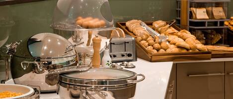 Un buffet proposant une variété de plats et comprenant tout le matériel nécessaire pour le service.