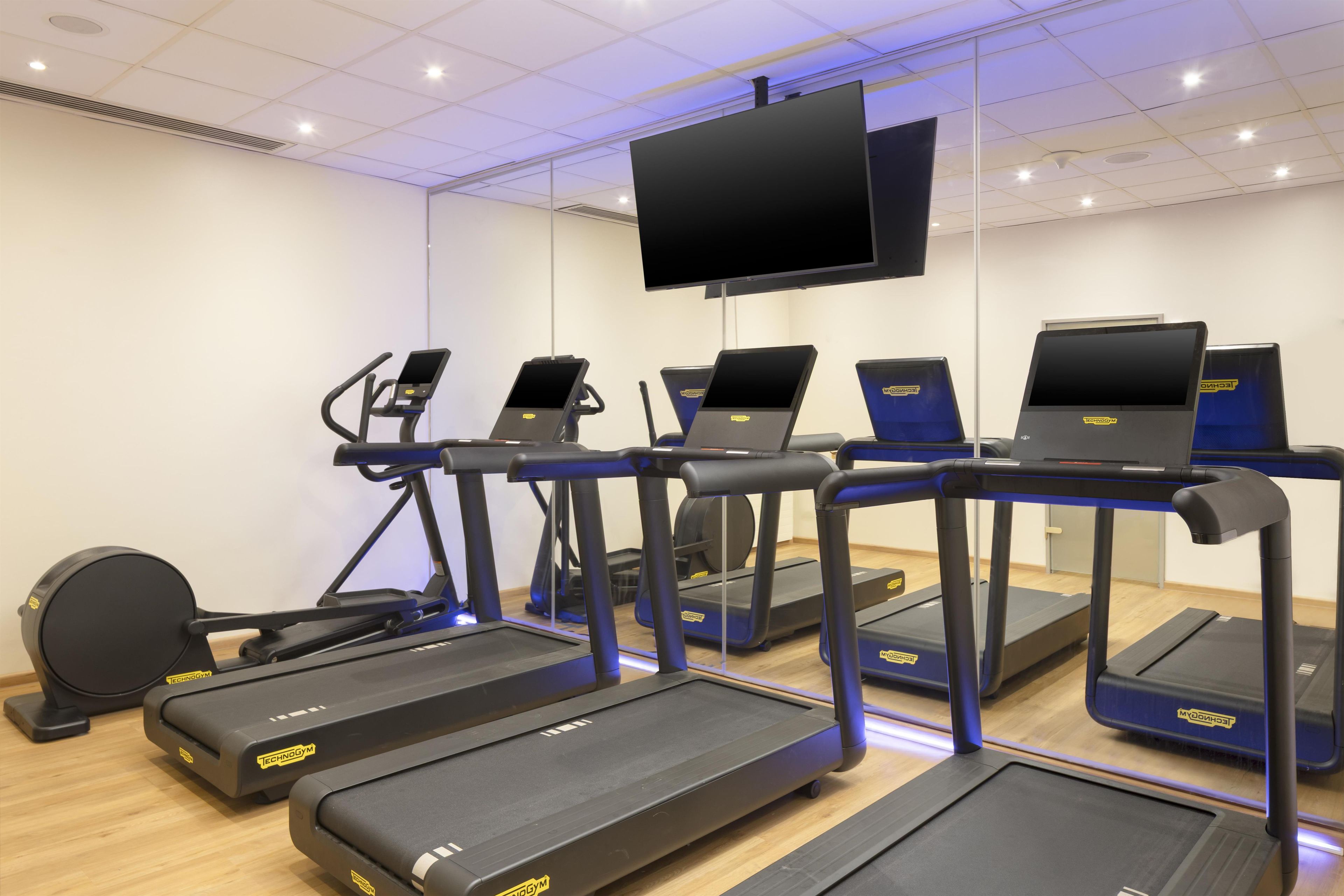 A fitness center with treadmills, elliptical machines, and a stationary bike.