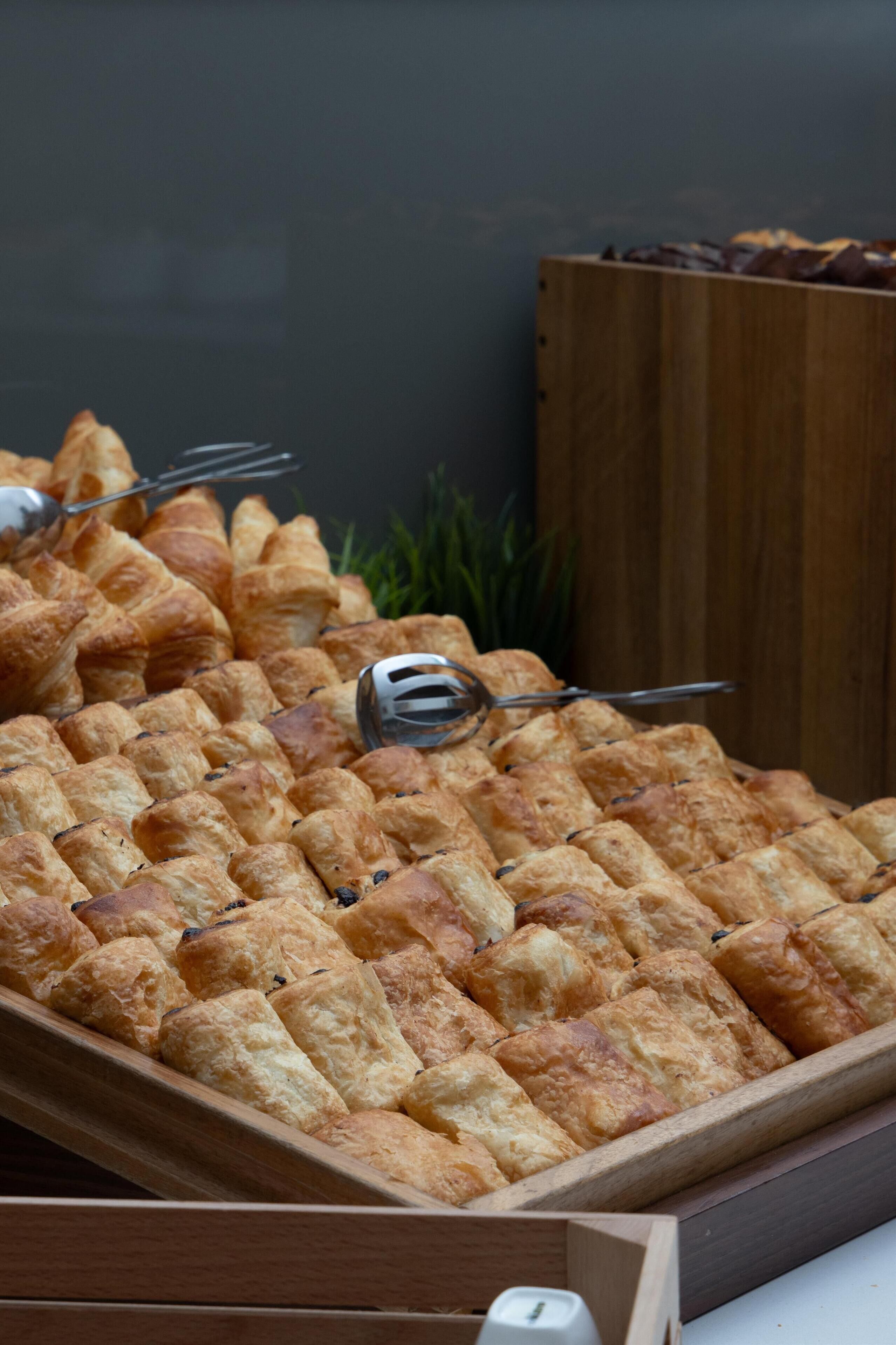 A tray of golden-brown pastries arranged in a wooden box.