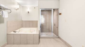 A modern bathroom with a bathtub, a shower, and a glass-enclosed shower area.