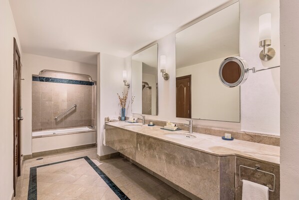 Une salle de bain moderne dotée d’une douche à l’italienne, d’un grand miroir et d’un long meuble-lavabo avec deux vasques.