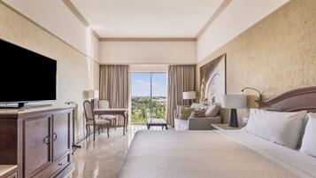 Relax in this stylish room featuring a large bed, TV, desk, and balcony with a view.
