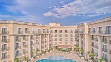 Alberca al aire libre, sombrillas en la alberca y camastros