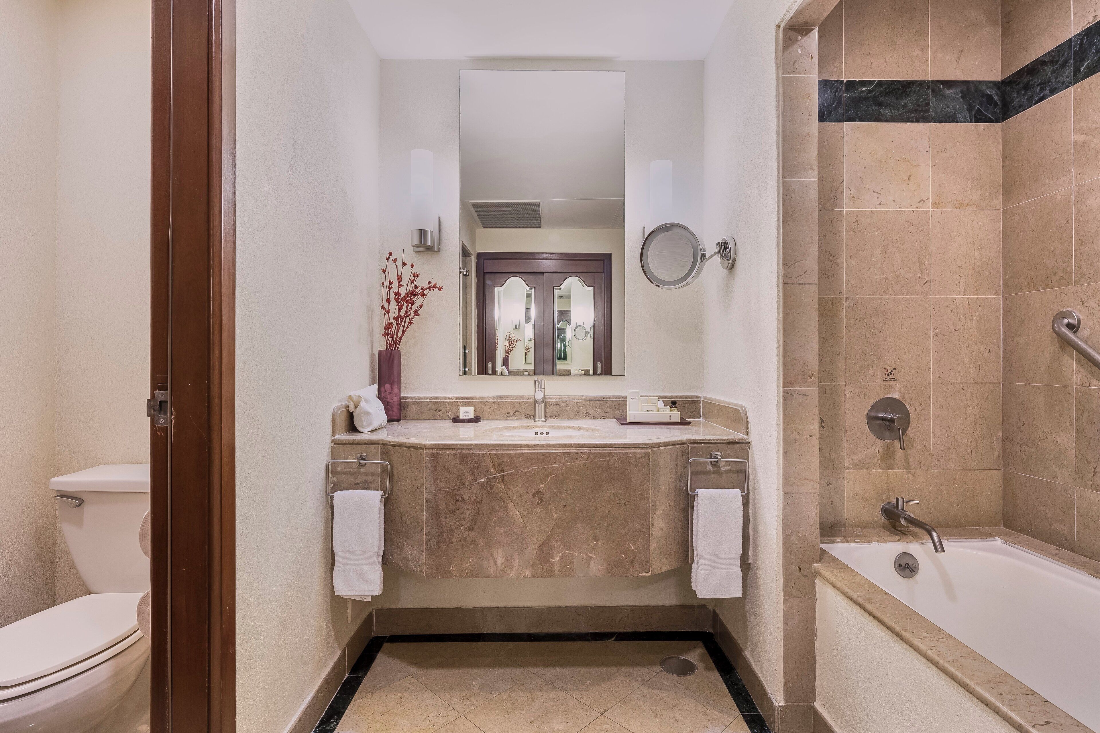 Un baño con lavamanos de mármol, bañera y retrete.