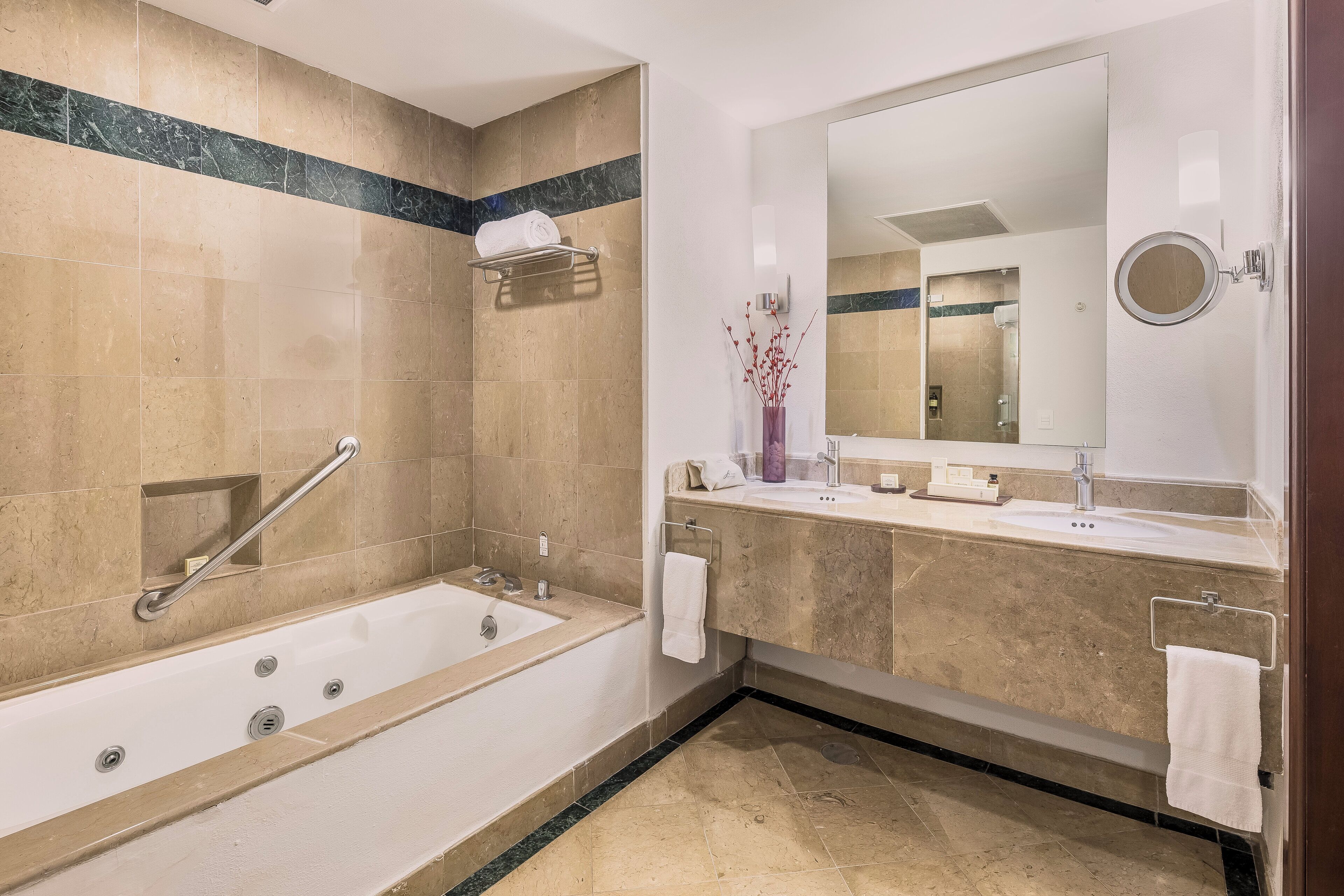 A modern bathroom with a bathtub, a large mirror, and a vanity with a sink.