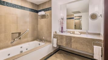 A modern bathroom with a bathtub, a large mirror, and a vanity with a sink.