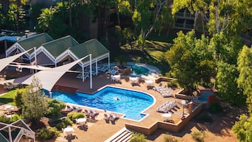 Una piscina al aire libre, tumbonas