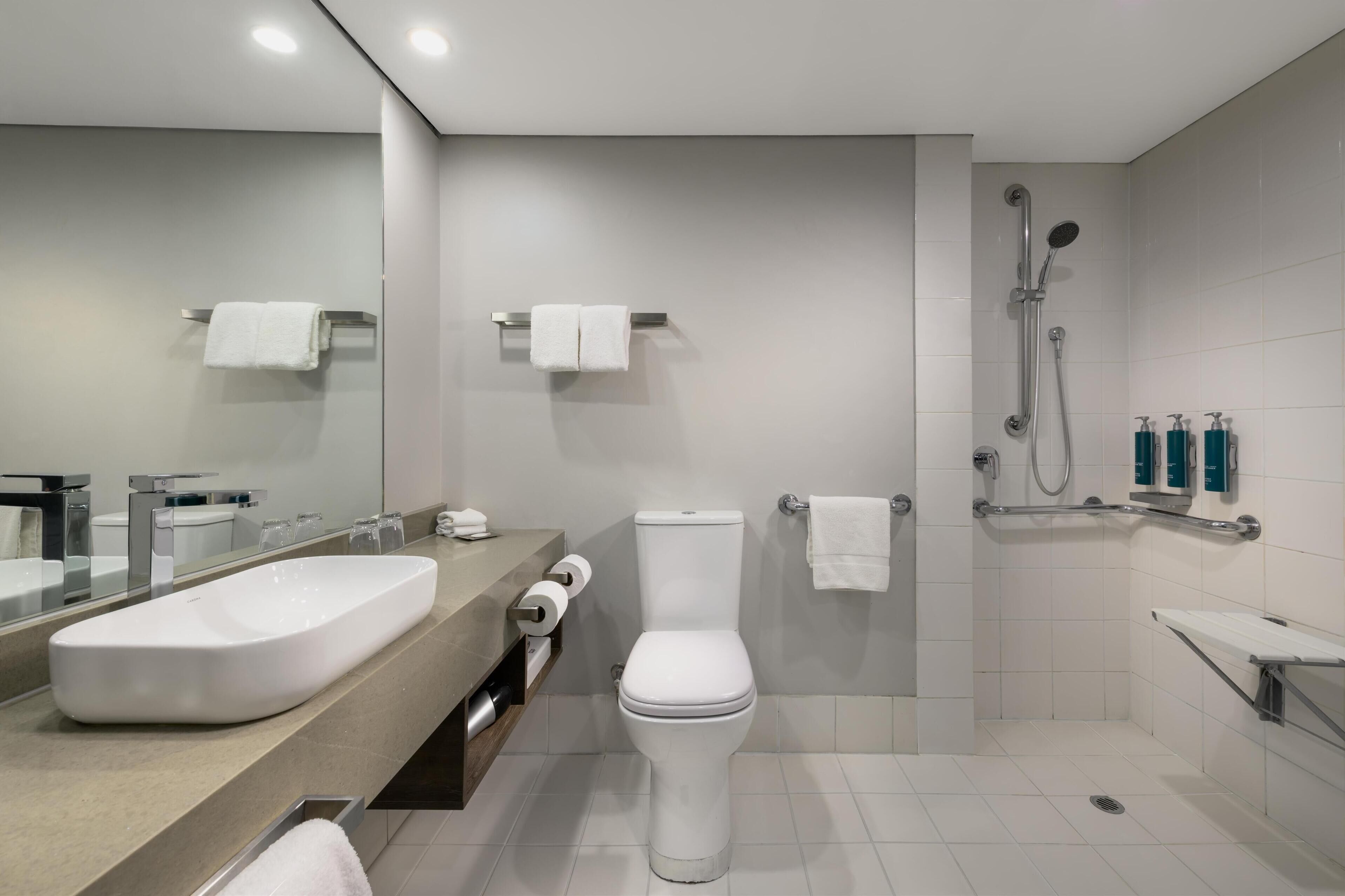 Et moderne badeværelse med stor vask, toilet og brusebad.