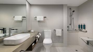 Et moderne badeværelse med stor vask, toilet og brusebad.