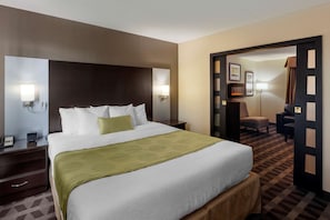 A hotel room with a large bed, bedside tables, a desk, and a chair.