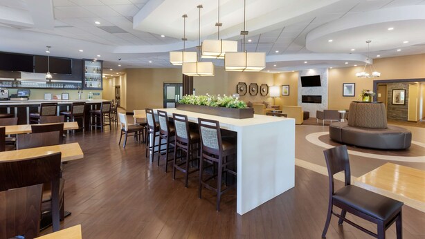 A modern hotel lobby with a central bar area, seating arrangements, and a fireplace. - Best Western Plus Leamington Hotel & Conference Centre (Leamington)