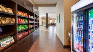 A clean, well-lit corridor with snack shelves on the left and a beverage refrigerator on the right. - Best Western Plus Leamington Hotel & Conference Centre (Leamington)