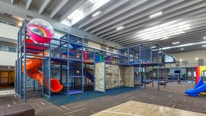 A spacious indoor play area with multiple slides and climbing walls, surrounded by a high ceiling and modern architecture. - Best Western Plus Leamington Hotel & Conference Centre (Leamington)
