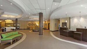 A spacious lobby with a reception desk, seating area, and a large pillar. - Best Western Plus Leamington Hotel & Conference Centre (Leamington)