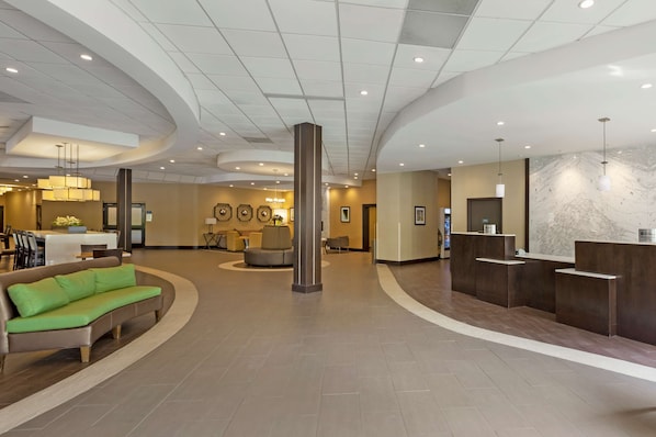 Un'ampia hall con reception, area salotto e un grande pilastro.