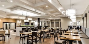 A modern restaurant with multiple dining areas, including a bar and seating arrangements.