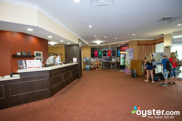A hotel reception area with a counter, a waiting area, and a view of the lobby.