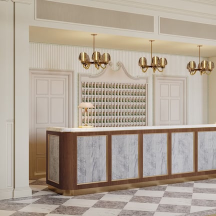 A reception area with a marble counter, a wall of framed photographs, and a chandelier.