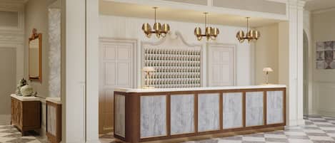 A reception area with a marble counter, a wall of framed photographs, and a chandelier.