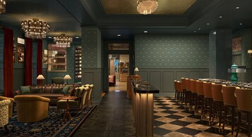 Un área de bar con suelo a cuadros, taburetes y una barra larga.