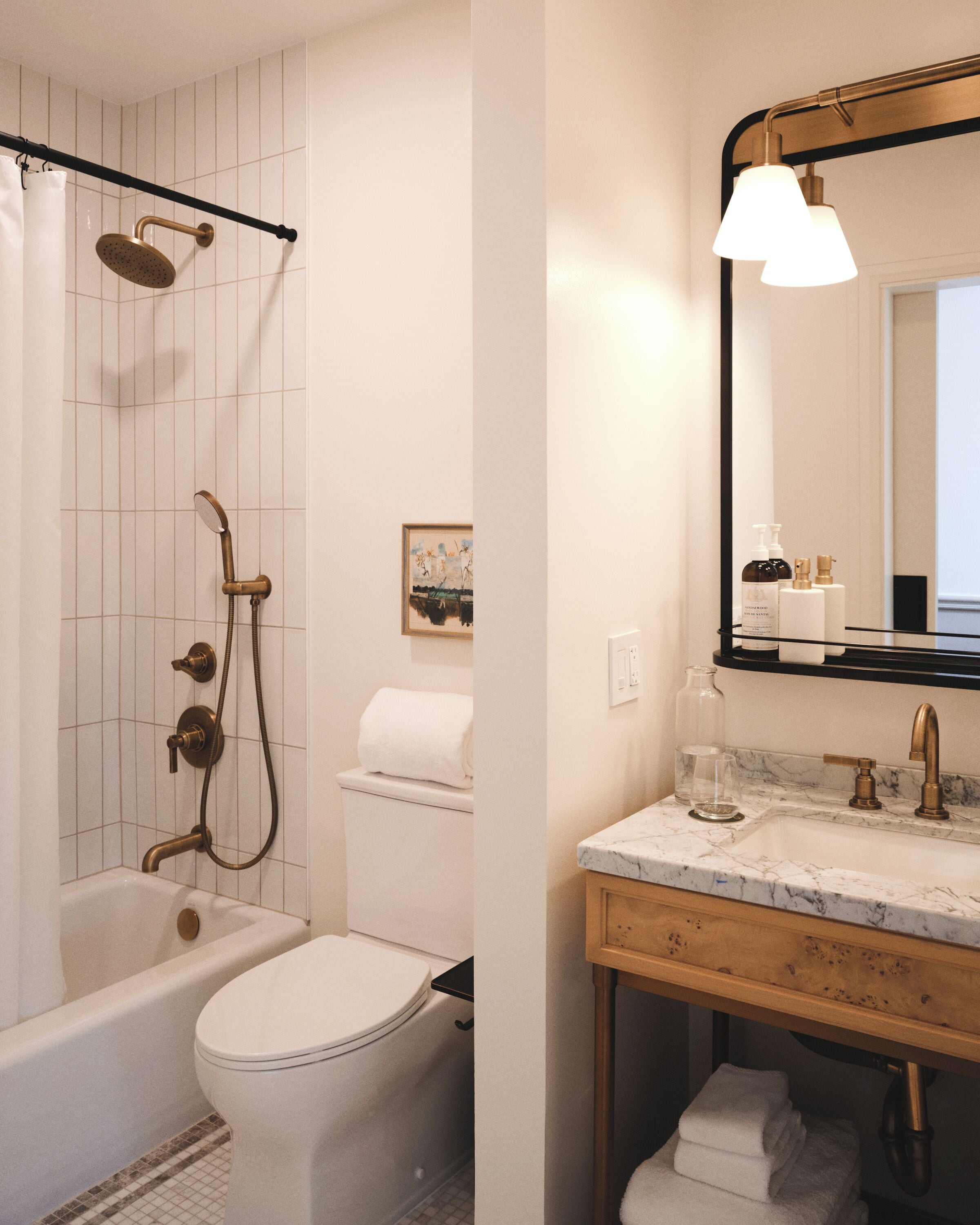 A bathroom with a bathtub, toilet, shower, and vanity with a mirror.