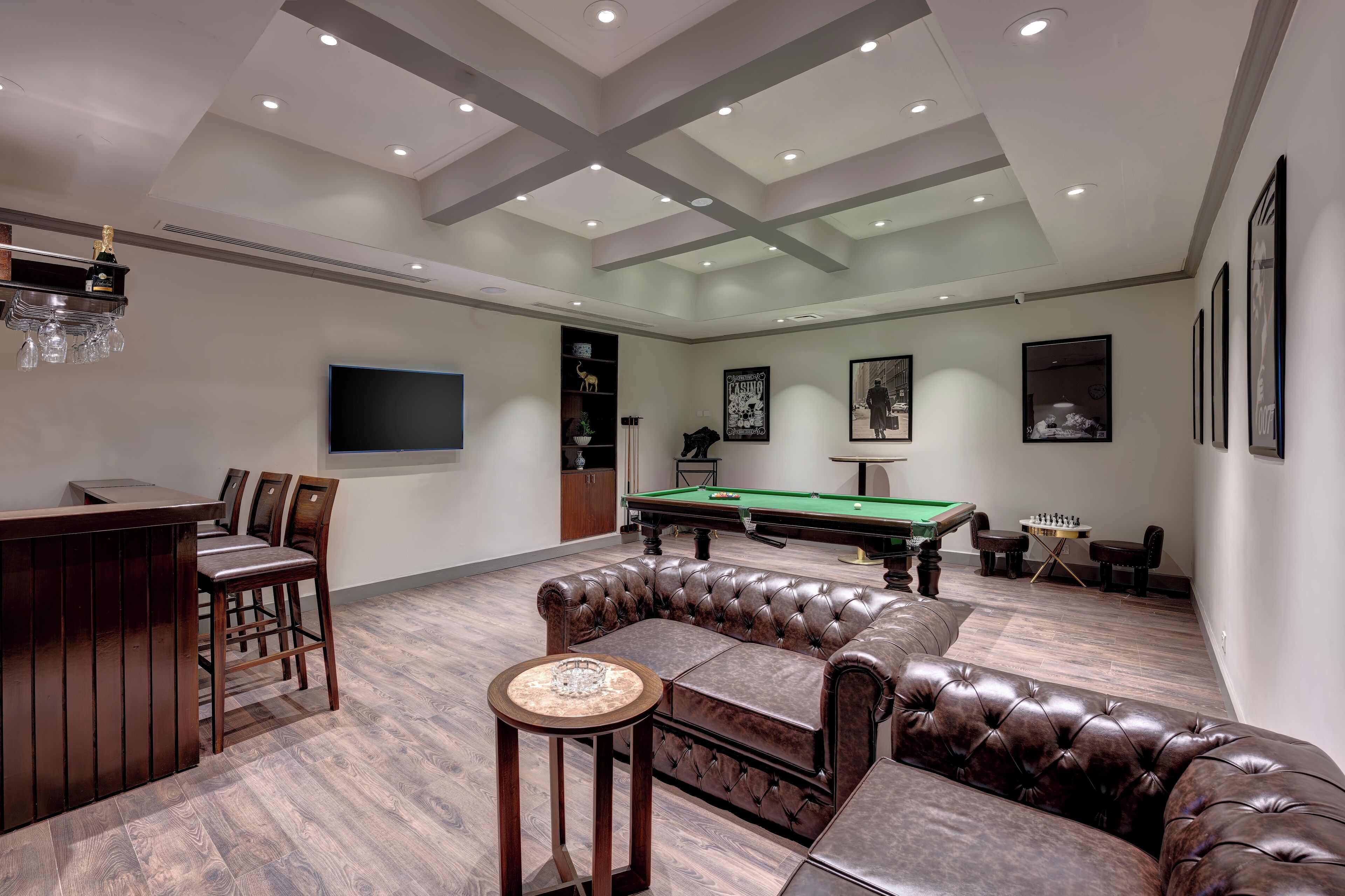 Amplia habitación con mesa de billar, sofá de cuero y zona de bar.