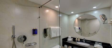 A modern bathroom with a glass-enclosed shower, a toilet, a sink, and a vanity with a mirror.