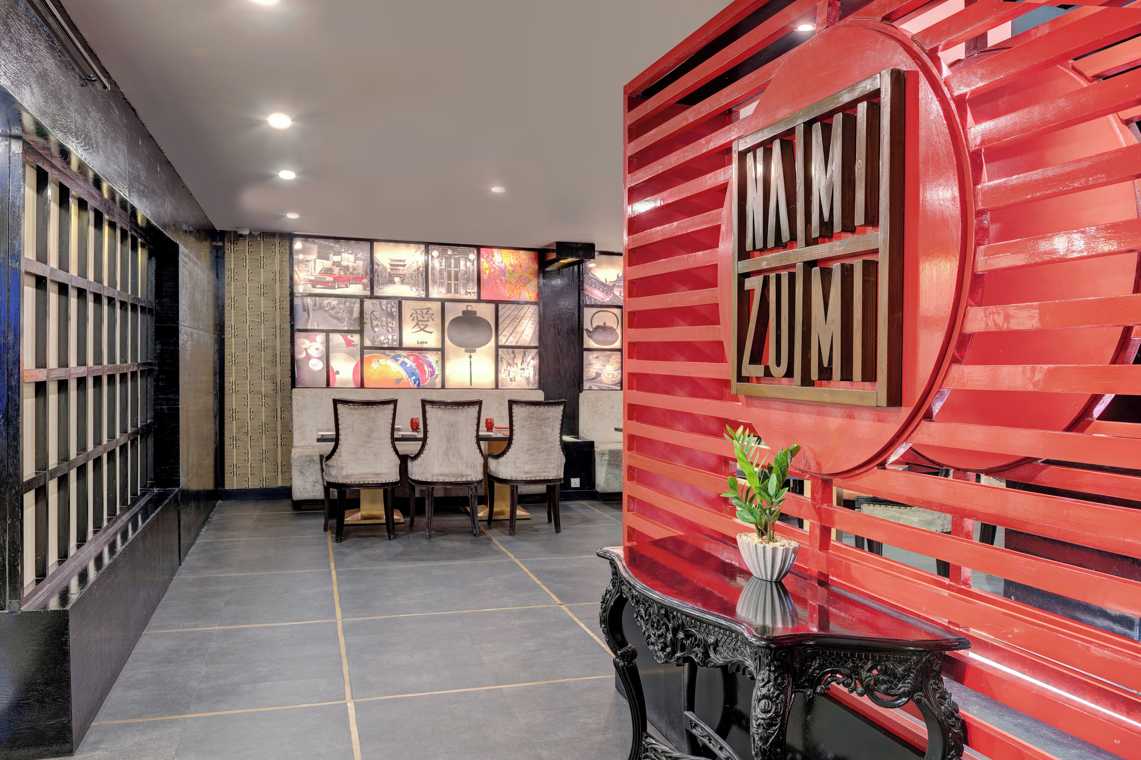 A lobby with a red wall, a reception desk, and a seating area with chairs.