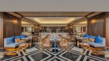 A spacious dining area with a long table, multiple chairs, and a bar in the background.