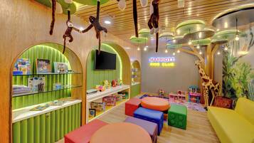 A children's play area with colorful seating, hanging toys, and a 'Marriott Kids Club' sign.