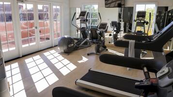A gym with treadmills, elliptical machines, and exercise bikes.