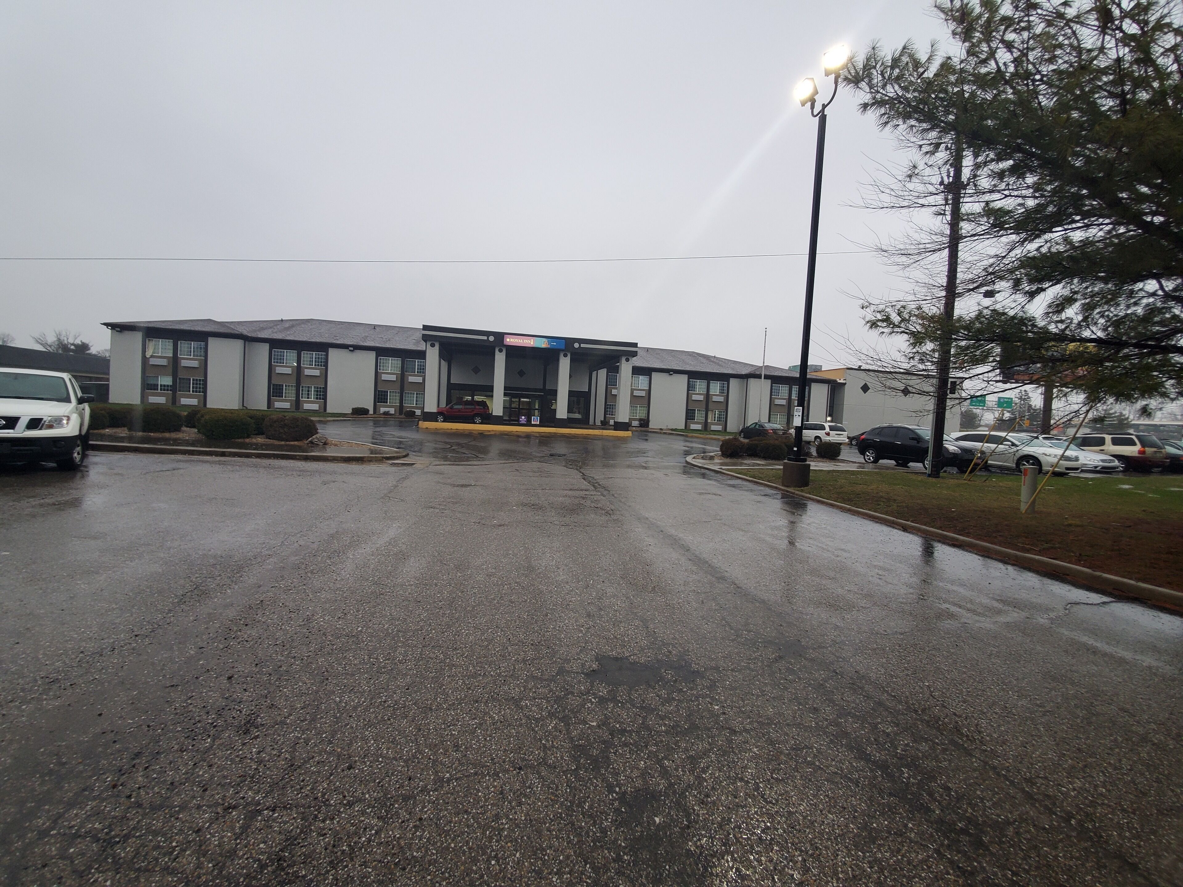A building with a covered entrance and a parking lot.